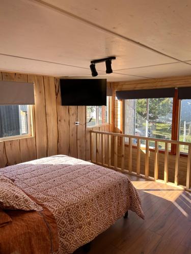 琼奇Cabaña Loft del Sur Premium的一间卧室配有一张床和一台平面电视