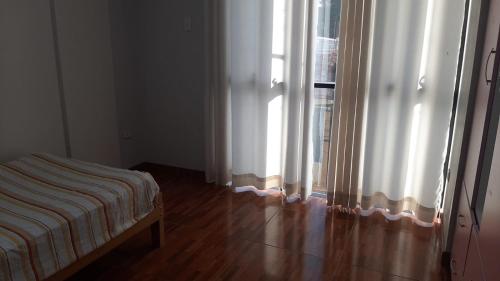 阿亚库乔AyacuchoDepa的一间卧室配有床和带窗帘的窗户