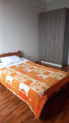 阿亚库乔AyacuchoDepa的卧室里一张带橙色和白色棉被的床