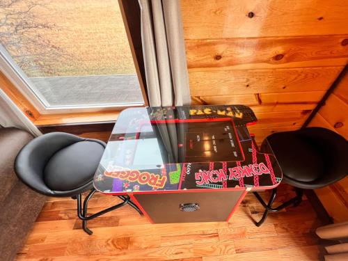 鸽子谷3 Master Bedrooms - Sleeps 10 - Location - Game Room - Hot Tub的一张玻璃桌,旁边是两把椅子,上面有电视
