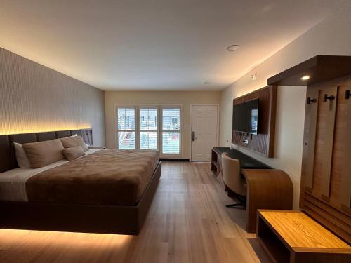 洛杉矶贝汶希尔汽车旅馆的一间卧室配有一张床、一张书桌和一台电视
