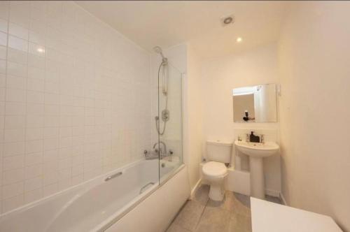 曼彻斯特NovaNest Salford Apartment的白色的浴室设有卫生间和水槽。