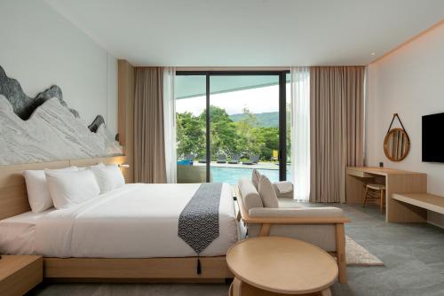 Ban Tha MaprangTimberton Resort Khaoyai的酒店客房设有一张床和一个大窗户