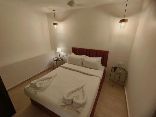 孟买The Majlis Hotel - Colaba Mumbai的一间小卧室,配有带两个枕头的床