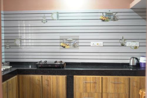 PonnampetCoorg Stream Side Homestay的厨房配有黑色台面和木制橱柜