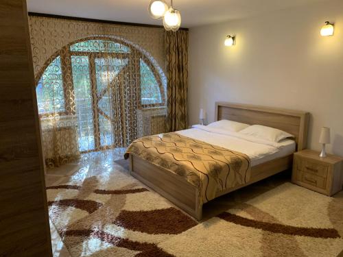 锡纳亚Casa Cristian的一间卧室设有一张床和一个大窗户