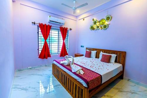 Kottakupam1BHK villa with swimming pool @ Dreamland的一间卧室配有红色窗帘的床