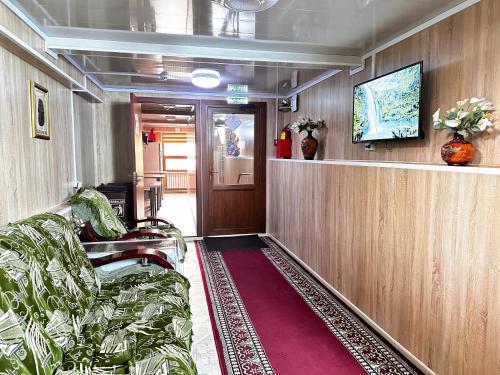 阿拉木图Bal-Meyir Hotel的客厅配有沙发和墙上的电视