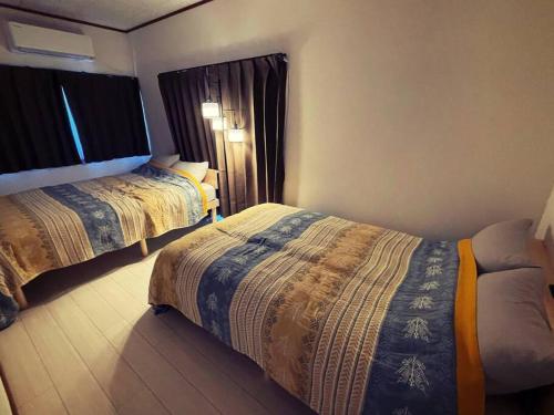 yadori TEN 宿り　甸的酒店客房设有两张床和窗户。