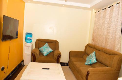 ThikaFully furnished one bedroom in Thika Cbd的客厅配有两把椅子和一张沙发