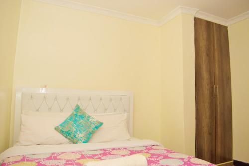 ThikaFully furnished one bedroom in Thika Cbd的卧室配有白色床和蓝色枕头