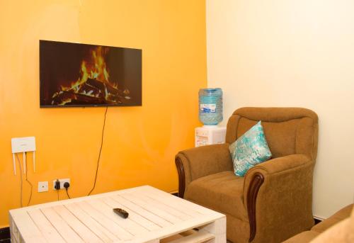ThikaFully furnished one bedroom in Thika Cbd的客厅配有椅子和壁炉