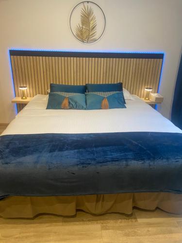 Saint-VictoretCôté spa的一间卧室配有一张带蓝色枕头的大床