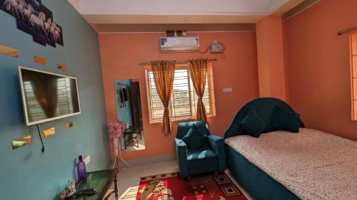 阿加尔塔拉Veda Homestay的卧室配有床、椅子和窗户。
