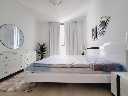 沙迦Luxury cozy apartment Al jda的白色卧室设有一张大床和镜子