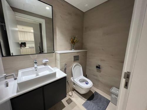 沙迦Luxury cozy apartment Al jda的一间带水槽、卫生间和镜子的浴室