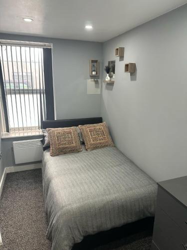 卡迪夫2 Bedroom Flat With Hot Tub的卧室配有白色墙壁上的床铺