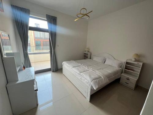 沙迦Cozy beautiful apartment Al zahia mall的白色的卧室设有床和窗户