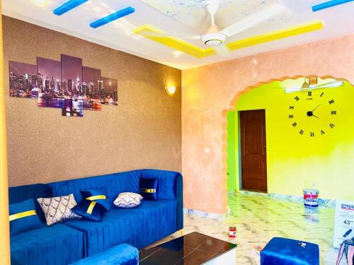 瓦加杜古Damsi immo的客厅配有蓝色的沙发和墙上的时钟