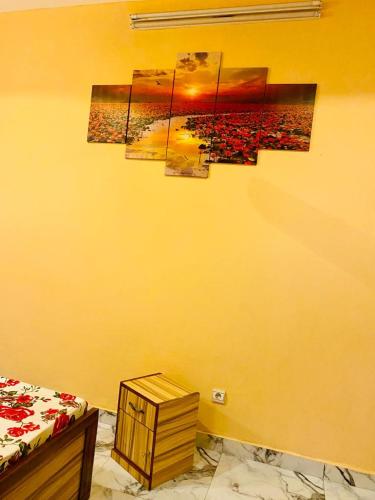 瓦加杜古Damsi immo的一间卧室,配有黄色的墙壁和绘画作品