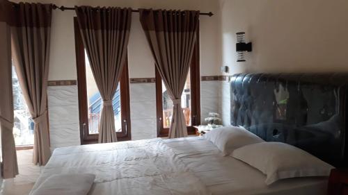 八丹拜Jepun Inn的卧室设有一张带窗户的白色大床