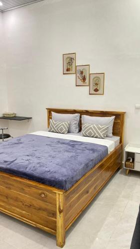 Juliana HomeStay的一间卧室配有一张带紫色床垫的木床