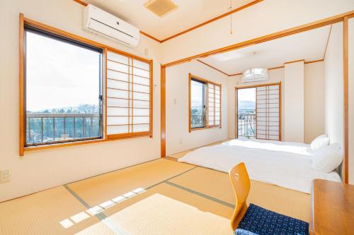 御殿场市富士見の宿的卧室配有一张床、一张书桌和窗户。