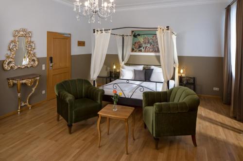 福森hideauts hotels Der Rosengarten的一间卧室配有一张床、两把椅子和一张桌子