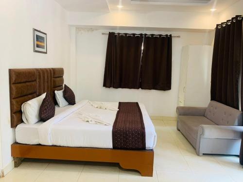 卡兰古特1 Bhk Apartment 200 mtr from beach的一间卧室配有一张床和一张沙发