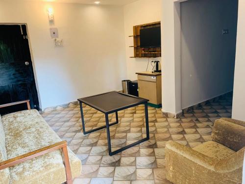 卡兰古特1 Bhk Apartment 200 mtr from beach的客厅配有桌子和两把椅子