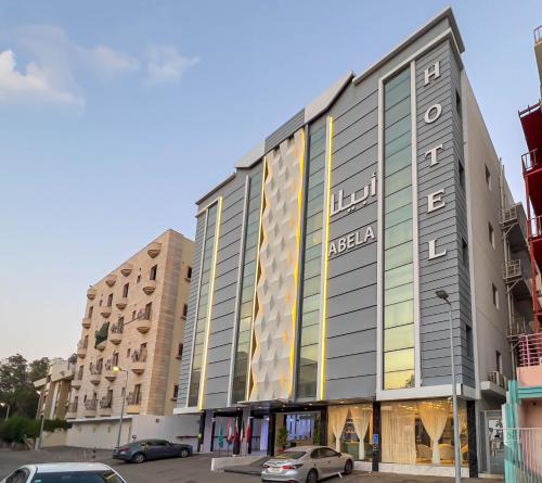 吉达Abela Alhamra Jeddah - Palestine Branch的停车场内停放汽车的大型建筑