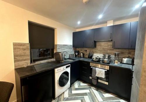 彼得伯勒New Apartment by DH ApartHotels的厨房配有黑色橱柜和白色洗碗机