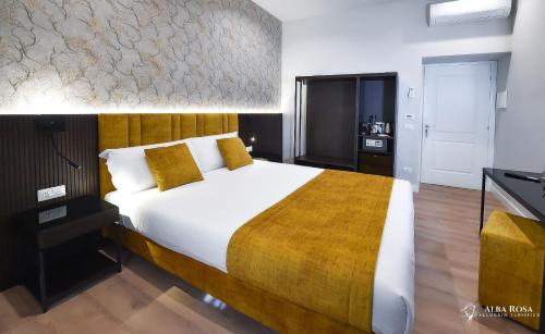 罗马Alba Rosa Rooms的一间卧室配有一张带黄色枕头的大床