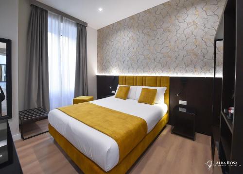 罗马Alba Rosa Rooms的一间卧室配有一张带黄色毯子的大床