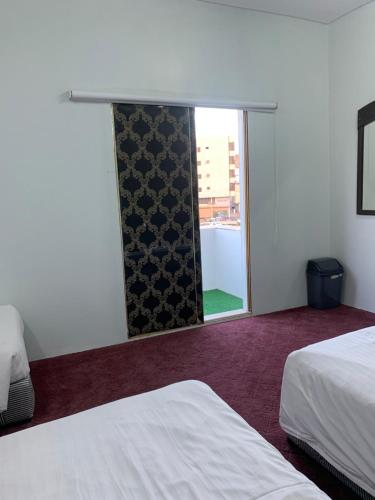 麦地那لينا للوحدات السكنية المفروشة的酒店客房设有两张床和窗户。