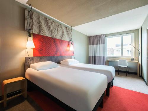 科涅克Hôtel Ibis Cognac Centre的酒店客房设有两张床和窗户。