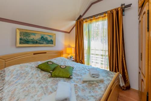 兹拉蒂博尔Vikendica Životić的一间卧室配有一张带两个绿袋的床