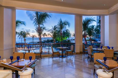 布里奇敦希尔顿巴巴多斯度假酒店 的一间带桌椅的海景餐厅