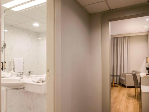 洛格罗尼奥卡尔顿里奥哈美居酒店的一间带水槽和镜子的浴室