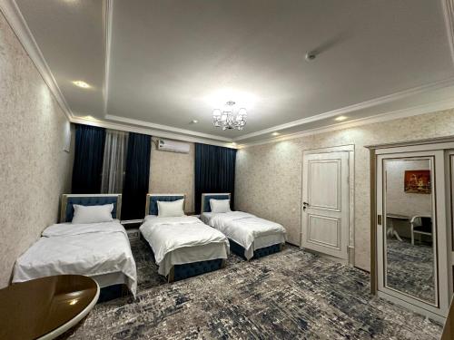 UzbankintyGulnora HOTEL的酒店客房设有两张床和一张桌子。