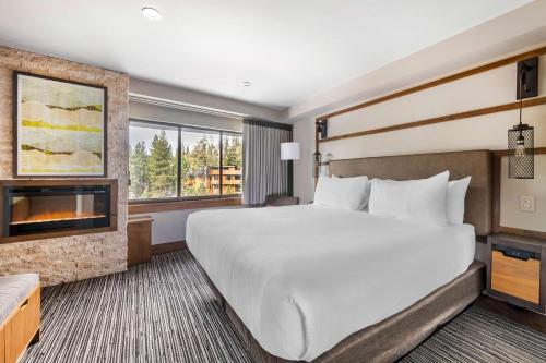 南太浩湖Hilton Vacation Club Tahoe Seasons Lake Tahoe的酒店客房设有一张大床和一个壁炉。