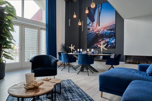 哈尔德韦克Captains Boathouse的客厅配有蓝色的沙发和桌子