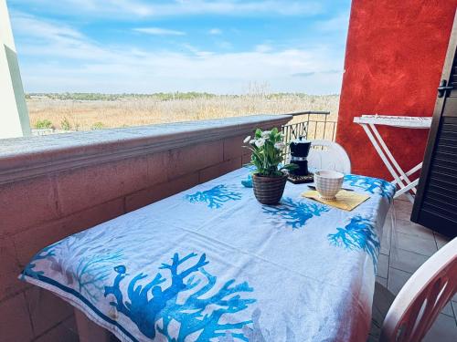 加利波利Gallipolitravel Residence Baia Verde的阳台上的桌子上摆放着蓝色和白色的毯子