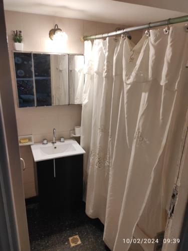 马德普拉塔Alquiler Temporada Casa 2 dormitorios para 6 personas的浴室配有淋浴帘和盥洗盆。