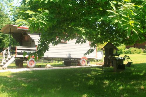 Saint-Vincent-en-BresseBelle Roulotte unique en pleine campagne Au Jardin de la Vouivre的一辆拖车,车上的房子坐在院子里