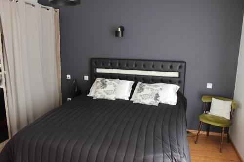 滨海勒韦尔东Chambre privée, Mer et Foret的一间卧室配有黑色床和白色枕头