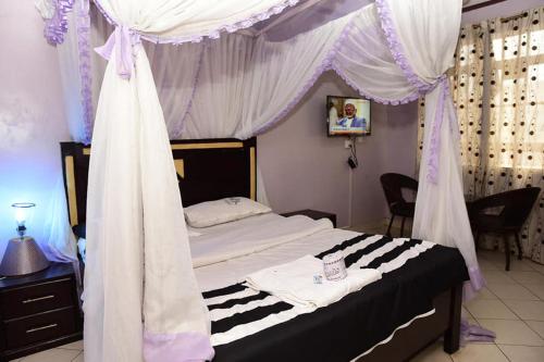 内罗毕Madola Hotel的一间卧室配有一张带天蓬的床