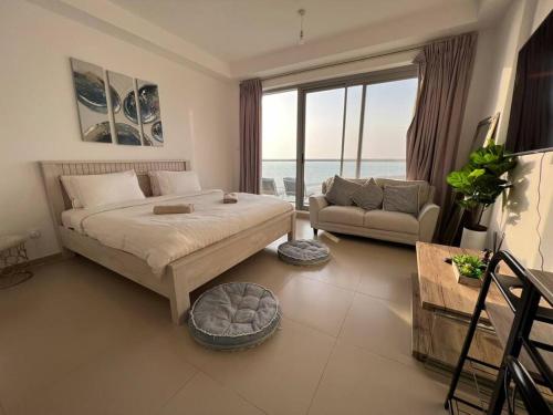 拉斯阿尔卡麦Sea-View Studio with Beach Access的一间卧室配有一张床、一张沙发和一个窗口