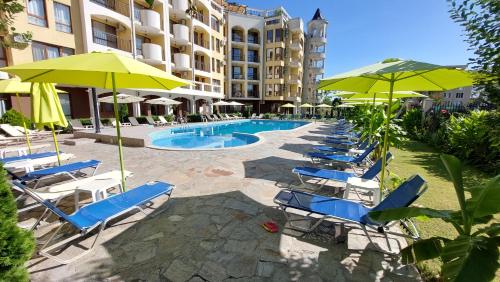 阳光海滩Diamond Palace的一组椅子和遮阳伞,位于游泳池旁