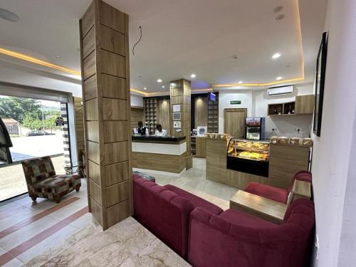 阿布贾Hotel 5092的一间带紫色沙发的客厅和一间厨房